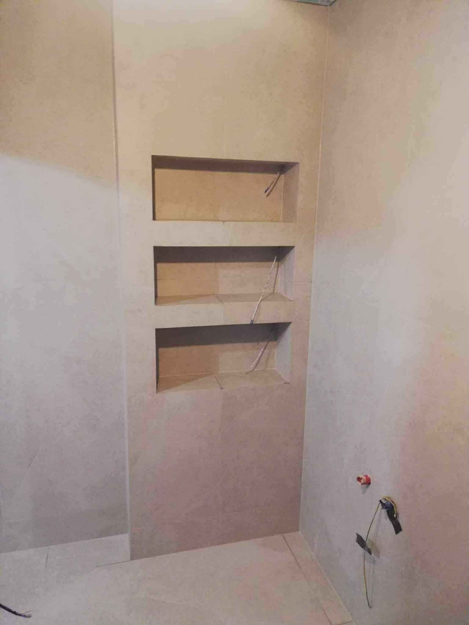 Dušo niša su trimis lentynomis smėlio spalvos didelio formato plytelėse