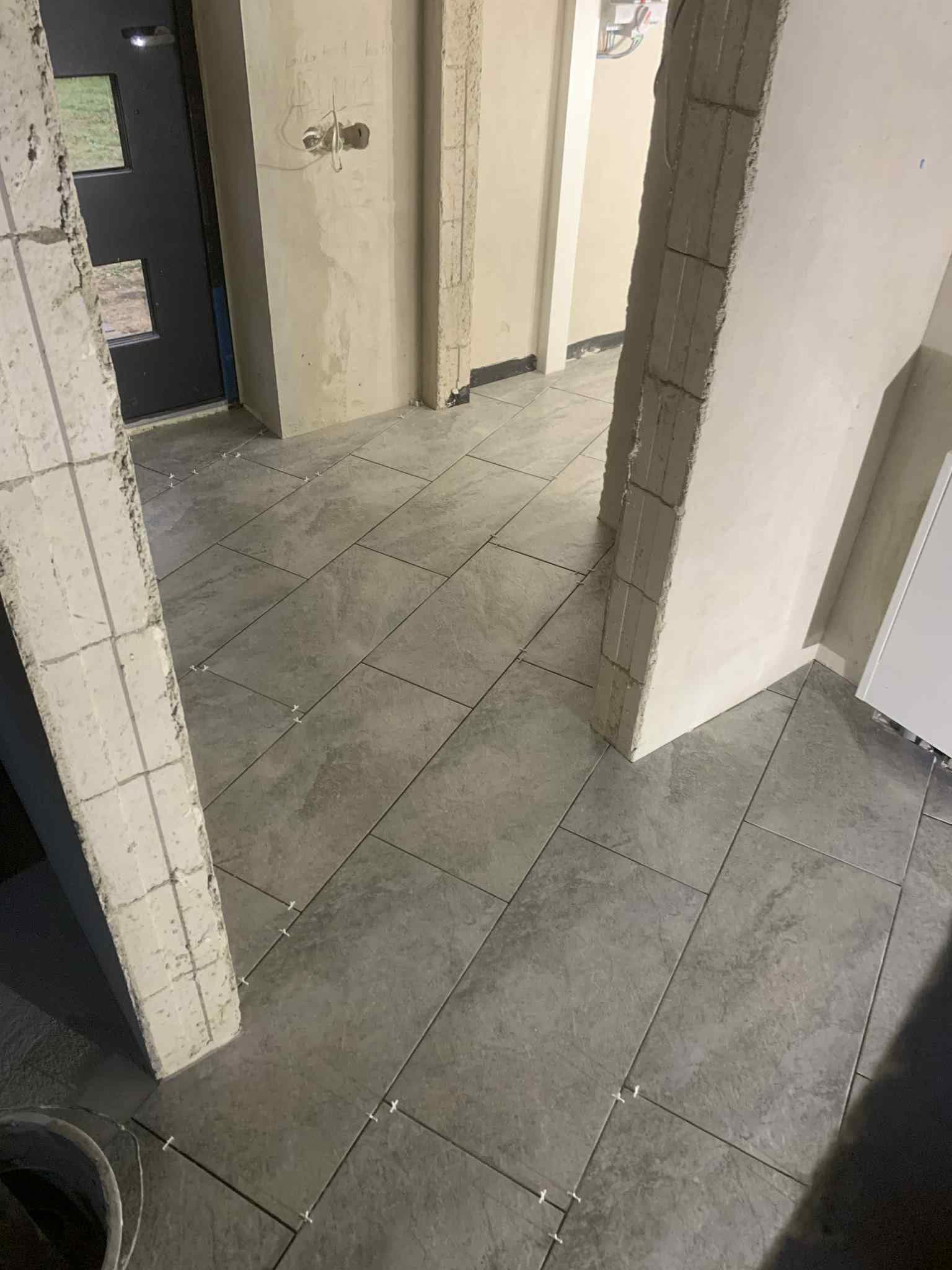Koridoriaus grindų plytelių klojimas su siūlių kryžiukais