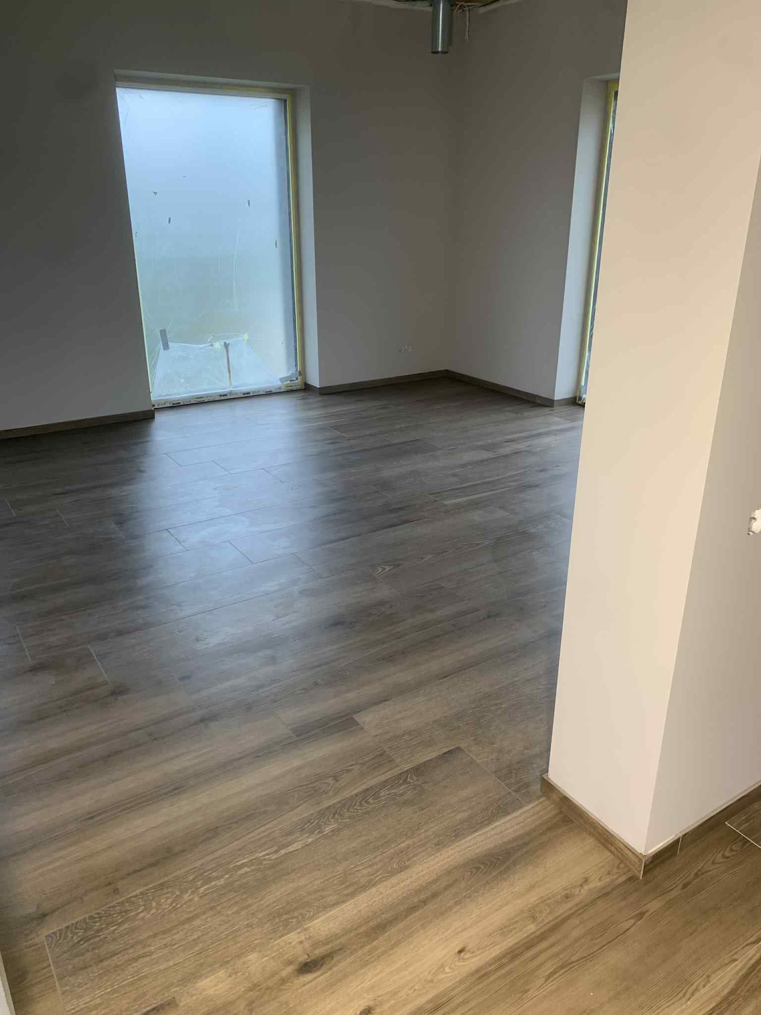 Medžio imitacijos didelio formato grindų plytelės naujo namo kambaryje