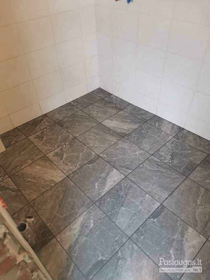 Pilkų marmuro imitacijos grindų plytelių klojimas įstrižai vonios kambaryje